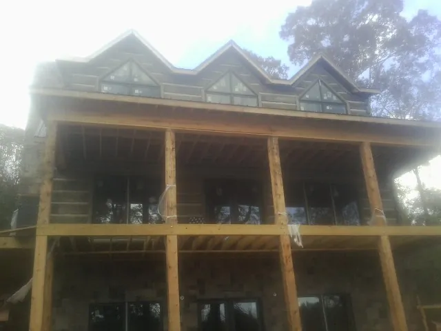 Dormers and porch framing on a large log home under construction — Roof Coating work by our crew in Reardan