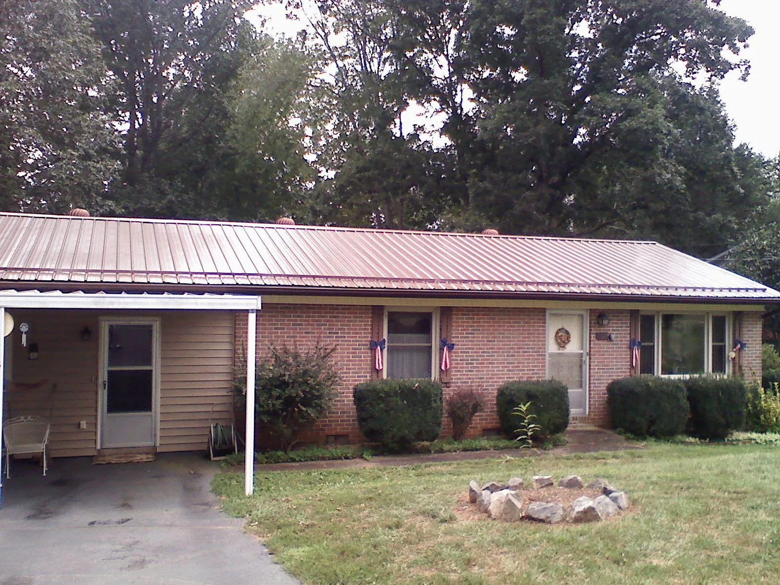 Bronze metal roof and carport on a brick ranch home — Roof Repair work by our crew in Reardan